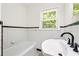 Updated bathroom features vintage tile, a black faucet and a tub with a shower at 3211 Hollydale Drive Sw, Atlanta, GA 30311