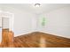 Bright bedroom features hardwood floors, neutral walls, and natural light from the window at 3211 Hollydale Drive Sw, Atlanta, GA 30311
