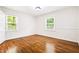 Bright bedroom features hardwood floors, white walls, a light fixture, and natural light from two windows at 3211 Hollydale Drive Sw, Atlanta, GA 30311