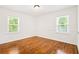 A clean bedroom boasts hardwood floors, white walls, and bright natural light from two windows at 3211 Hollydale Drive Sw, Atlanta, GA 30311