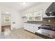 Bright kitchen has white cabinets, double sink, granite countertops, and tiled floor at 3211 Hollydale Drive Sw, Atlanta, GA 30311