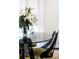 A contemporary dining table is set with a glass top and retro chairs, bathed in soft natural light at 620 Glen Iris Dr # 223, Atlanta, GA 30308