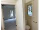 Half bath featuring a window over toilet, doorway to additional room with gray carpeting at 2552 White Oak Dr, Decatur, GA 30032