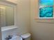 Powder room with a sink, toilet, mirror, and window for natural light at 2552 White Oak Dr, Decatur, GA 30032