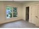 Bedroom with large window and gray carpet leads into an ensuite bathroom with tile flooring at 2552 White Oak Dr, Decatur, GA 30032