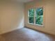 Cozy bedroom featuring a large window overlooking lush greenery and gray carpet at 2552 White Oak Dr, Decatur, GA 30032