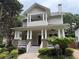 Charming two-story home featuring a welcoming front porch with brick and white pillars and mature landscaping at 2552 White Oak Dr, Decatur, GA 30032