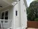 Side view of the home's exterior showcasing neutral siding, white trim, and a glimpse of the charming front porch at 2552 White Oak Dr, Decatur, GA 30032