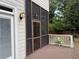 View of a cozy screened-in porch with wood flooring and door leading to back yard at 2552 White Oak Dr, Decatur, GA 30032