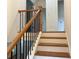 Staircase with wooden steps, a railing, and black iron balusters, leading to the upper level at 2552 White Oak Dr, Decatur, GA 30032