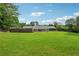 Large backyard features lush green grass and a view of the home's back exterior and covered patio at 3280 Pebble Hill Dr, Marietta, GA 30062