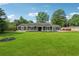 Expansive front yard view of a single-story house with lush green grass and mature trees at 3280 Pebble Hill Dr, Marietta, GA 30062