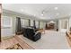 Open-concept living area with plush carpet, large leather sectional, and access to the outdoors at 4665 Idlewood Dr, Cumming, GA 30040