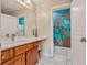 Bathroom with marble counters, wood cabinets, modern faucets, and tropical mural in adjoining shower room at 630 Birch River Ln, Lawrenceville, GA 30043