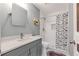Well-lit bathroom featuring a modern vanity, updated sink fixtures, and a shower with a butterfly curtain at 630 Birch River Ln, Lawrenceville, GA 30043