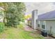 Home's backyard view with a small patio and AC unit with a lush, partially wooded area at 6304 Kendra Ln, Lithonia, GA 30058
