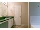 Bathroom featuring a vanity with dark green countertop, mirror, and tiled floors at 6304 Kendra Ln, Lithonia, GA 30058