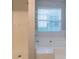 Bathroom featuring a white tiled bathtub, window, and shower at 6304 Kendra Ln, Lithonia, GA 30058