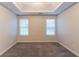 Bright carpeted bedroom with tray ceiling and natural light from two windows at 6304 Kendra Ln, Lithonia, GA 30058
