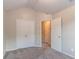 Carpeted bedroom featuring a pitched ceiling, double closet and interior door at 6304 Kendra Ln, Lithonia, GA 30058