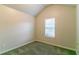 Small carpeted bedroom with pitched ceiling and natural light from window at 6304 Kendra Ln, Lithonia, GA 30058