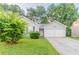Charming single-Gathering home features a two-car garage, lush lawn, and mature trees at 6304 Kendra Ln, Lithonia, GA 30058