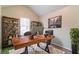 Well-lit home office features a large desk, shelves, and neutral carpet at 6304 Kendra Ln, Lithonia, GA 30058