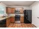 Well-lit kitchen featuring stainless steel appliances, wooden cabinets, and a black refrigerator at 6304 Kendra Ln, Lithonia, GA 30058