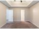Spacious carpeted main bedroom featuring a tray ceiling and neutral walls at 6304 Kendra Ln, Lithonia, GA 30058
