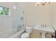 Bright bathroom featuring a white tiled shower, soaking tub, and pedestal sink at 1640 Nottingham Ne Way, Atlanta, GA 30309