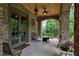 Inviting covered porch featuring a ceiling fan, brick accents, and outdoor seating area at 1640 Nottingham Ne Way, Atlanta, GA 30309