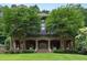 Elegant brick home featuring a covered front porch, manicured lawn, and mature trees at 1640 Nottingham Ne Way, Atlanta, GA 30309