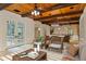 Open concept living area with wood beams, comfortable seating, and access to outdoor spaces at 1640 Nottingham Ne Way, Atlanta, GA 30309