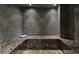 Beautiful home sauna with pebble tile walls and stone bench seating, creating a luxurious spa experience at 1640 Nottingham Ne Way, Atlanta, GA 30309