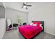 Cozy bedroom with bright pink bedding, a ceiling fan, carpet flooring, and natural light at 116 Eleanora Park, Loganville, GA 30052