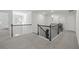 Spacious upstairs hallway with gray carpet and black iron railing provides view to rooms at 116 Eleanora Park, Loganville, GA 30052