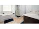 Bright bathroom with a soaking tub, separate shower, and neutral-toned flooring at 319 Nobleman Way, Canton, GA 30114