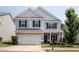 Charming two-story home with a well-manicured lawn, two car garage, and classic architectural details at 319 Nobleman Way, Canton, GA 30114