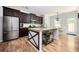 Modern kitchen featuring stainless steel appliances, a large island, granite countertops, and dark wood cabinets at 319 Nobleman Way, Canton, GA 30114