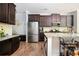 Bright kitchen features stainless steel appliances, granite countertops, custom dark wood cabinets, and a kitchen island at 319 Nobleman Way, Canton, GA 30114