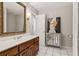 Bathroom with wooden vanity, white countertops, an ornate mirror, and a neutral-toned wall at 3445 Strawberry Ln, Cumming, GA 30041