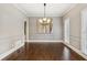 Spacious dining room with wainscoting detail, dark wood floors, and modern light fixture at 3445 Strawberry Ln, Cumming, GA 30041