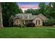 Charming brick home with manicured lawn and lush landscaping under a beautiful sunset at 3445 Strawberry Ln, Cumming, GA 30041