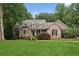 Beautiful brick home featuring a well-maintained lawn, mature trees, and manicured shrubs at 3445 Strawberry Ln, Cumming, GA 30041
