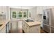 Bright kitchen features stainless appliances, granite countertops, large island, hardwood floors and natural light from large windows at 3445 Strawberry Ln, Cumming, GA 30041