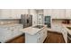 Bright kitchen features white cabinets, stainless appliances, granite countertops, kitchen island and hardwood floors at 3445 Strawberry Ln, Cumming, GA 30041
