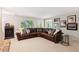 Spacious living room features a leather sectional, brick fireplace, and access to the outdoors at 3445 Strawberry Ln, Cumming, GA 30041