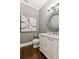 Chic powder room featuring a floating vanity, designer mirror, and hardwood floors at 3445 Strawberry Ln, Cumming, GA 30041