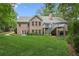 View of the back of the home showcasing the brick exterior, deck, and well-kept lawn at 3445 Strawberry Ln, Cumming, GA 30041