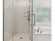 Bright bathroom featuring a glass enclosed shower with a handheld shower and patterned window over a jetted tub at 3445 Strawberry Ln, Cumming, GA 30041